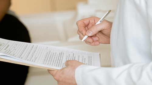 Médecin en blouse blanche tenant un rapport écrit