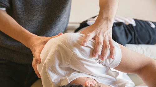Personne manipulant le dos d'un patient