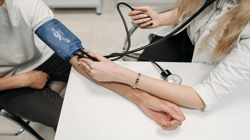 Doctoresse réalisant une prise de tension sur une personne