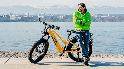 Photo d'un homme appuyé sur un vélo jaune de la marque Miloo