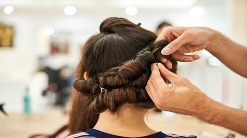 Femme de dos, chez le coiffeur, avec un chignon tressé