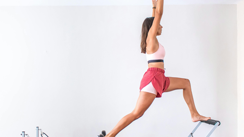 Image d'une jeune femme en train de faire du Pilates Reformer sur une machine