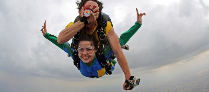 Une image de 'Freefly' - Adobe Stock Un non-voyant saute en parachute accroché sur le dos de son instructeur, les deux sourient et le non-voyant se masque les yeux.